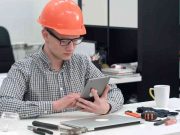Architect with safety helmet using electronic tablet in the office