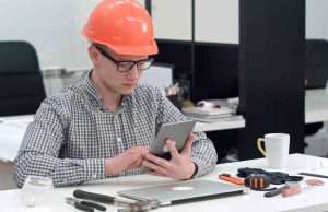 7 Advantages of Acquiring Online Safety Certificates Architect with safety helmet using electronic tablet in the office